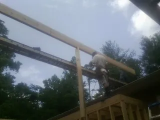 Carpenter setting a ridge beam over a new addition frame — Ice Dam Removal by Roofing Brothers in Mendon
