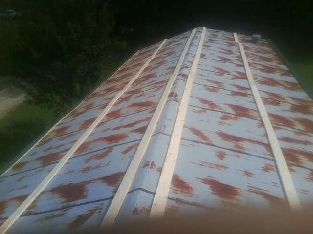 Rusted metal roof panels with new wood purlins before replacement — Storm Damage Roof Repair in Mendon by Roofing Brothers